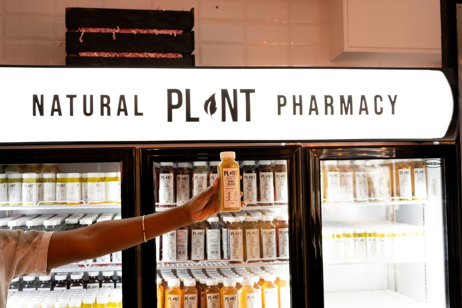 a man holding a bottle of liquid in front of a store